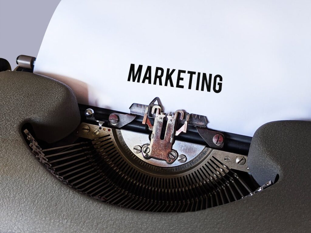 Close-up of a vintage typewriter with the word 'Marketing' on paper, conveying a retro business theme.